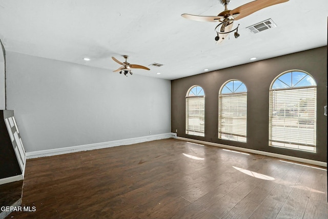 empty room with visible vents, wood finished floors, and ceiling fan