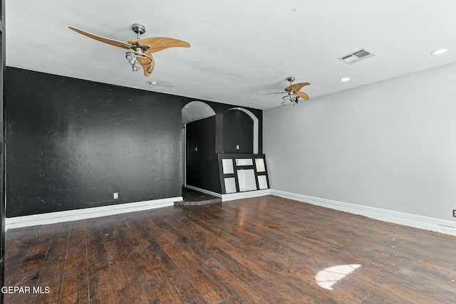 empty room with a ceiling fan, visible vents, wood-type flooring, and baseboards