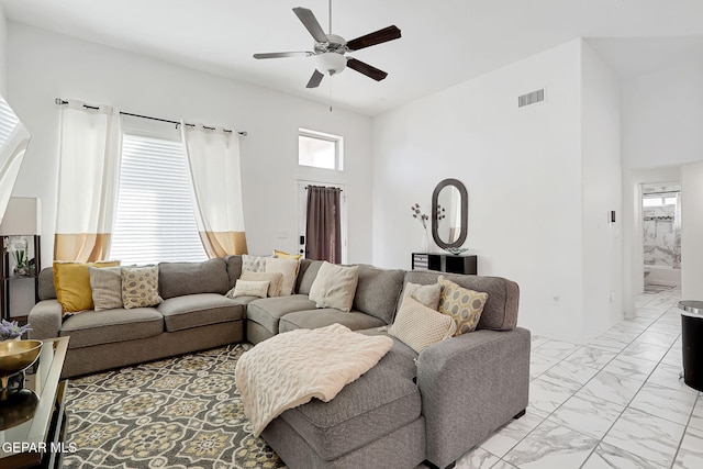 living area featuring visible vents, marble finish floor, a high ceiling, and ceiling fan