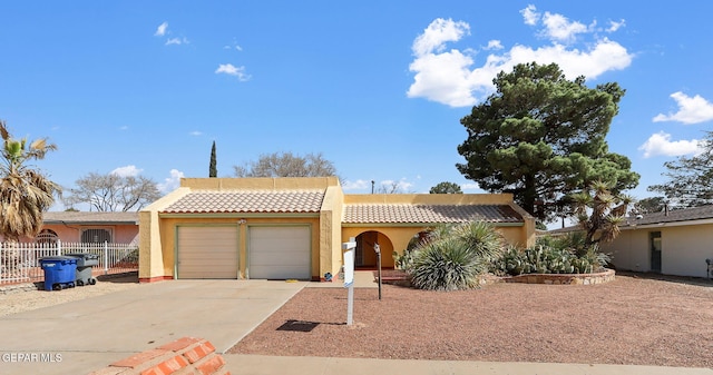 view of front of property featuring fence, stucco siding, concrete driveway, a garage, and a tiled roof