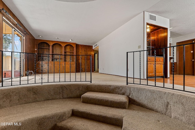 carpeted living room with visible vents and a textured ceiling