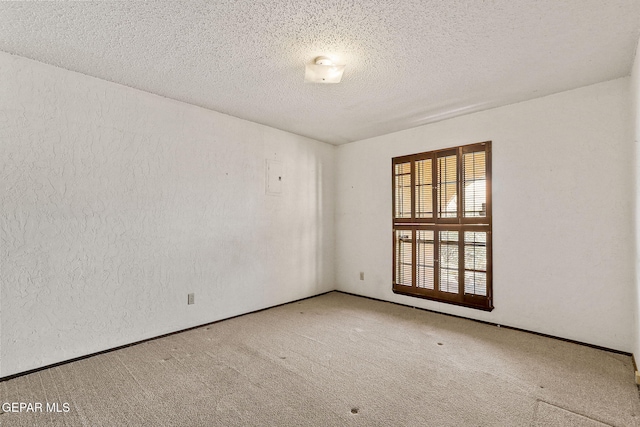 empty room featuring a textured ceiling, carpet, and a textured wall