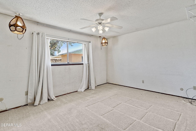 spare room featuring a textured ceiling, a ceiling fan, and light carpet