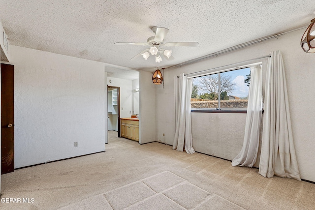 unfurnished bedroom with light carpet, a textured ceiling, ceiling fan, and a textured wall