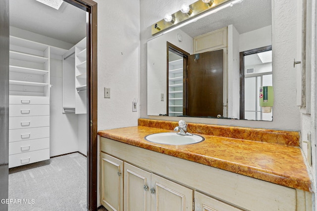 bathroom with vanity and a textured wall