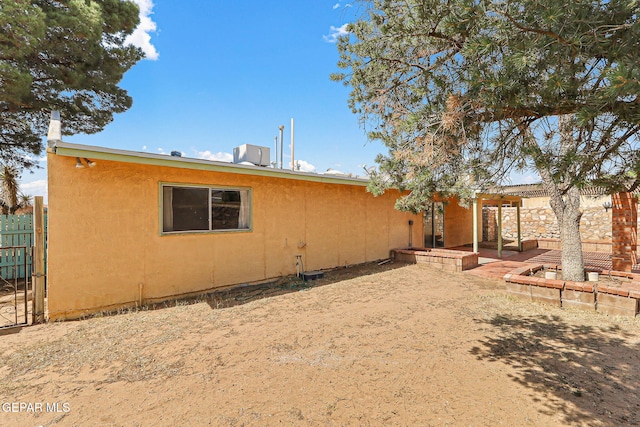 back of house featuring a patio area, central air condition unit, stucco siding, and fence