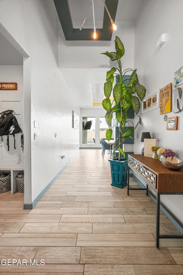 hallway featuring baseboards and wood tiled floor