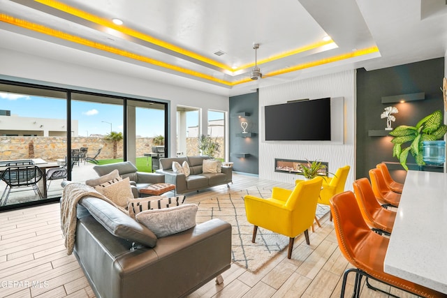 living room with visible vents, a raised ceiling, a fireplace, and wood tiled floor