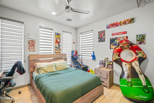 bedroom with light wood-type flooring, visible vents, baseboards, and ceiling fan