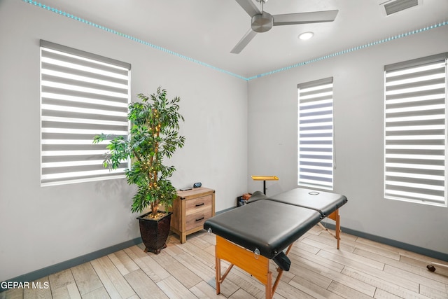 game room with visible vents, baseboards, ceiling fan, and wood tiled floor