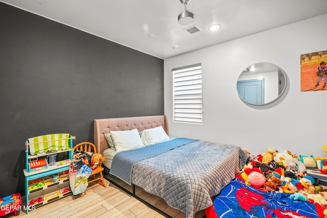 bedroom featuring visible vents and wood finished floors