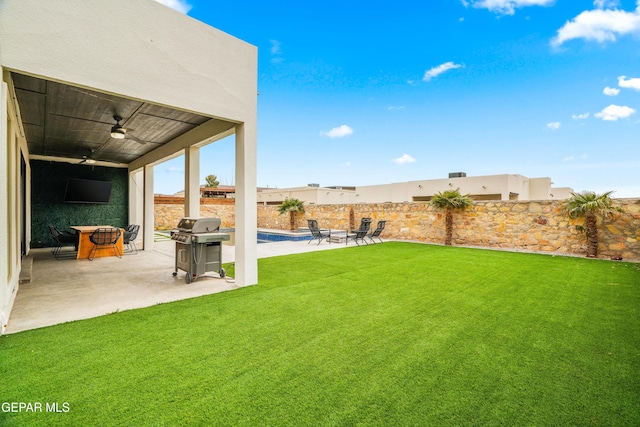 view of yard featuring a fenced in pool, a patio, a fenced backyard, and a ceiling fan