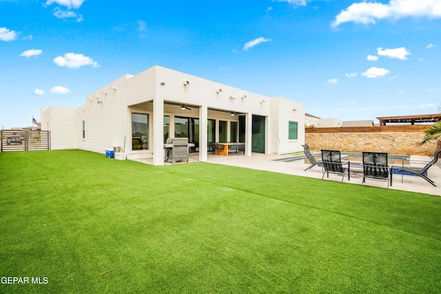 back of property with stucco siding, a patio, a ceiling fan, and fence