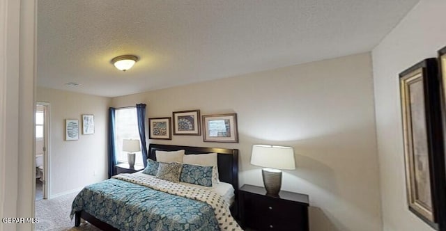 bedroom featuring visible vents, baseboards, a textured ceiling, and carpet flooring