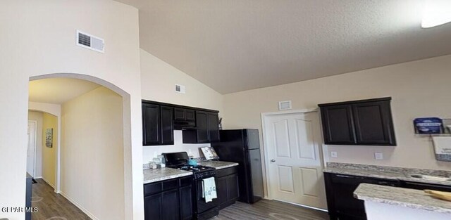 kitchen with dark wood finished floors, black appliances, dark cabinetry, and visible vents