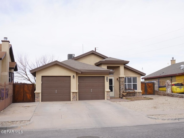 ranch-style home with stone siding, stucco siding, a garage, and fence