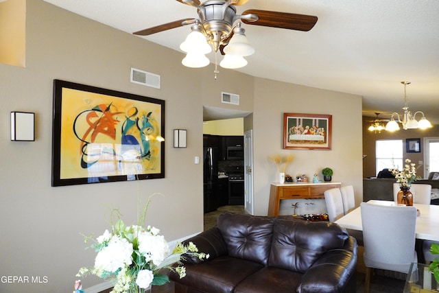 living area featuring visible vents and ceiling fan with notable chandelier