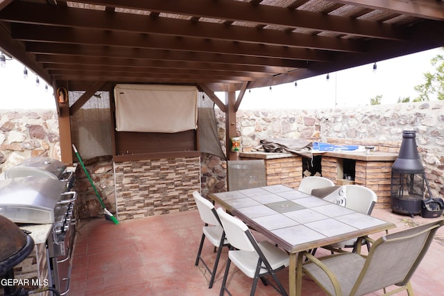 view of patio featuring outdoor dining area, exterior kitchen, and a pergola