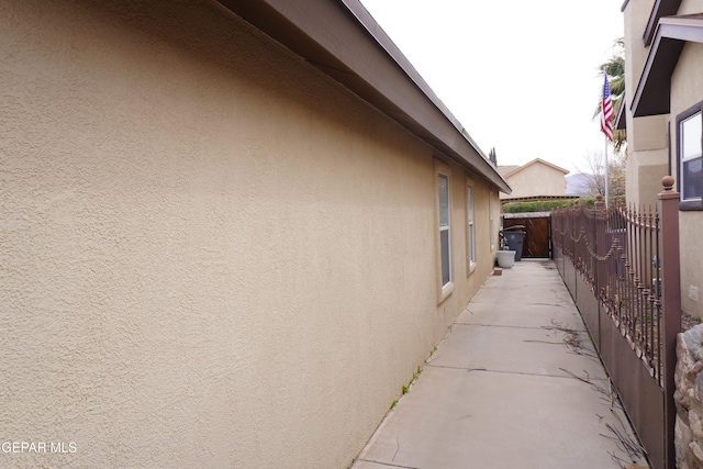 view of home's exterior featuring stucco siding and fence