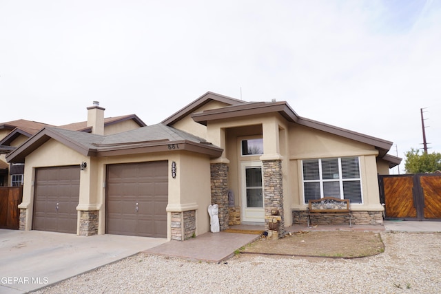 view of front of home featuring fence, stucco siding, driveway, stone siding, and an attached garage