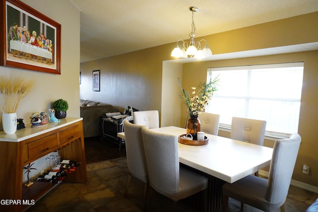 dining space with stone finish floor and a notable chandelier