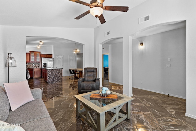 living area with visible vents, arched walkways, marble finish floor, and vaulted ceiling