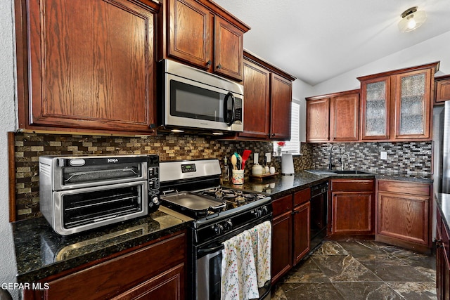 kitchen with lofted ceiling, a toaster, a sink, decorative backsplash, and stainless steel appliances