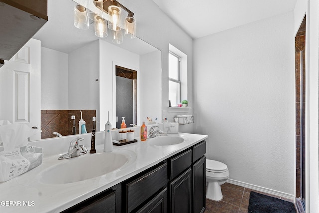 bathroom with double vanity, tile patterned floors, toilet, and a sink