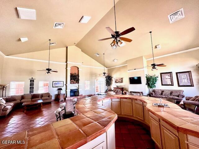 kitchen featuring tile countertops, visible vents, open floor plan, and ceiling fan