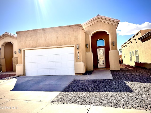 view of front of home featuring concrete driveway, an attached garage, and stucco siding