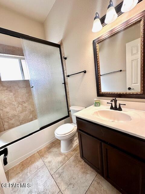 full bath with enclosed tub / shower combo, tile patterned floors, toilet, and vanity