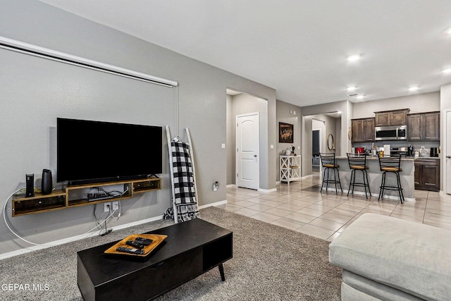 living room featuring light tile patterned flooring, recessed lighting, and baseboards