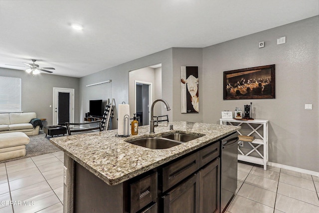 kitchen featuring a ceiling fan, an island with sink, a sink, dark brown cabinetry, and dishwasher