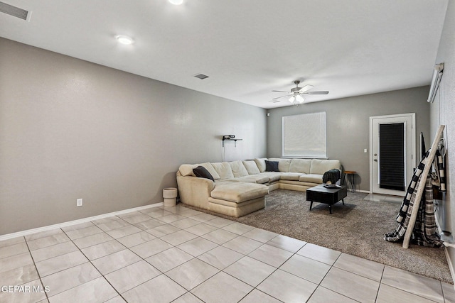 living room featuring light tile patterned floors, a ceiling fan, visible vents, and baseboards