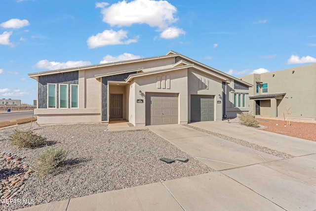 view of front facade featuring a garage, driveway, and stucco siding