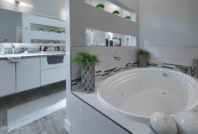 full bathroom with a jetted tub and vanity