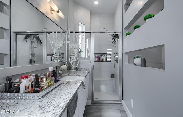 bathroom with a shower stall, vanity, and wood finished floors