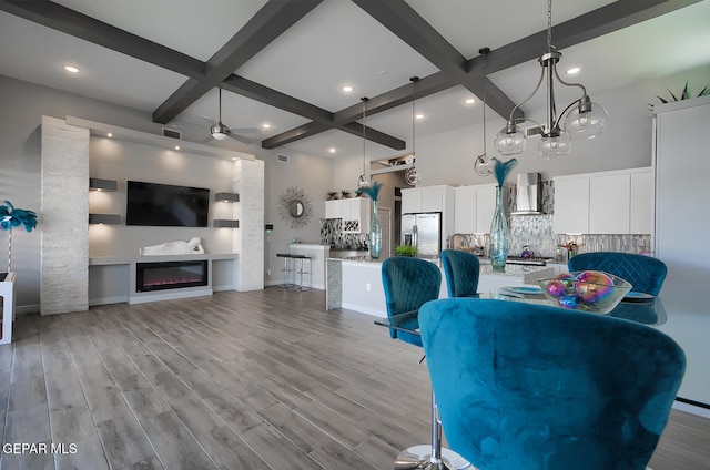 unfurnished living room featuring beam ceiling, coffered ceiling, and wood finished floors