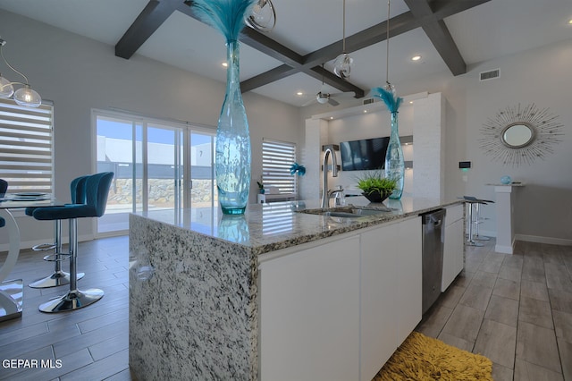 kitchen with visible vents, wood tiled floor, a sink, pendant lighting, and stainless steel dishwasher