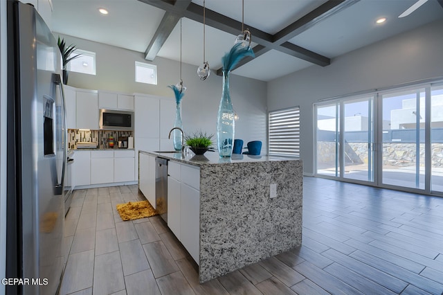 kitchen featuring a sink, beam ceiling, white cabinets, and stainless steel appliances