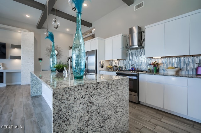 kitchen with tasteful backsplash, visible vents, light stone counters, appliances with stainless steel finishes, and wall chimney exhaust hood