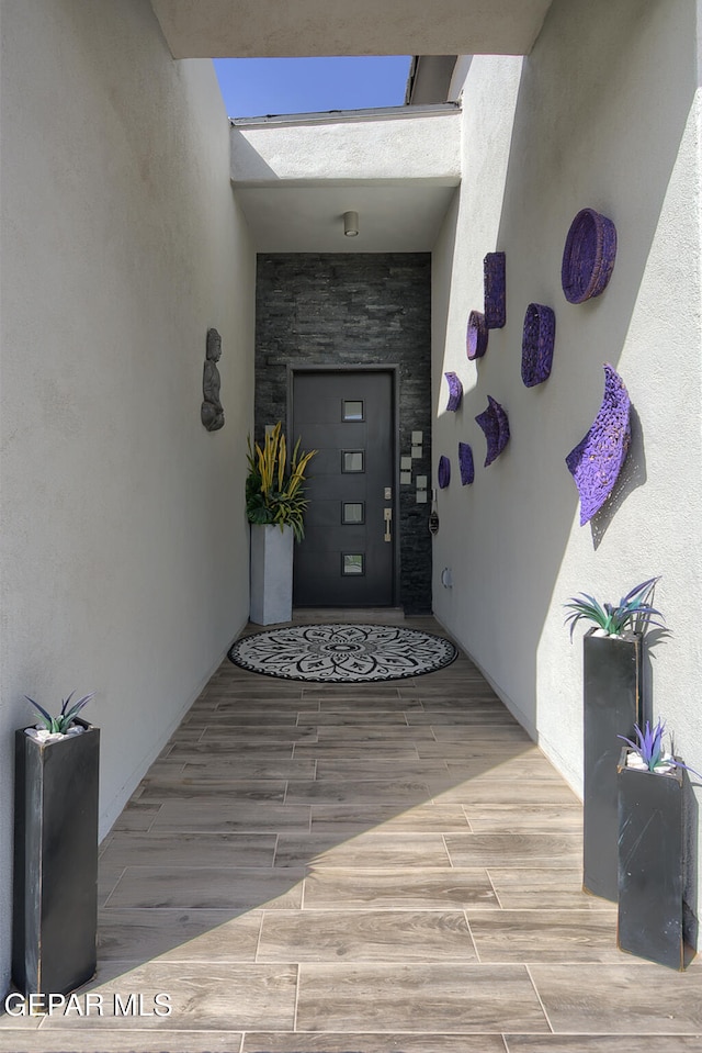 entrance to property featuring stone siding and stucco siding