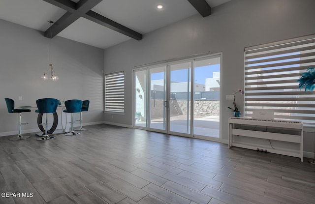 interior space featuring baseboards, an inviting chandelier, and wood finished floors