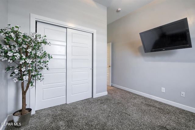 unfurnished bedroom featuring a closet, baseboards, and carpet floors