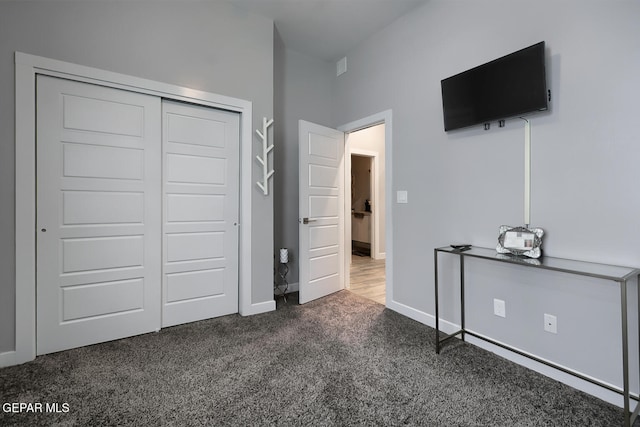 unfurnished bedroom featuring a closet, carpet flooring, and baseboards