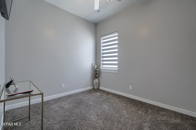 carpeted spare room featuring ceiling fan and baseboards