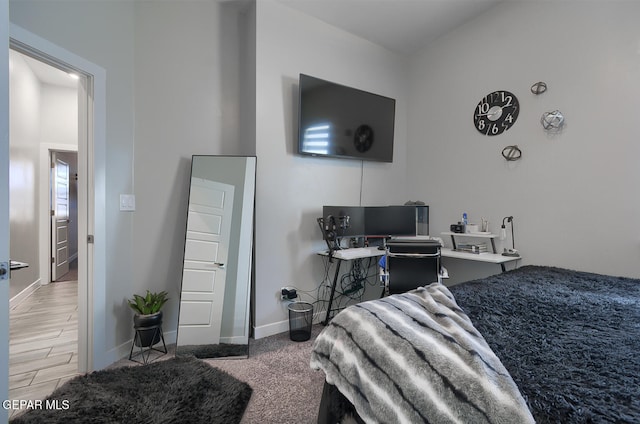 bedroom featuring baseboards and wood finished floors