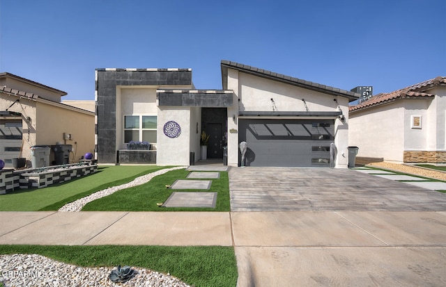 contemporary home featuring stucco siding, an attached garage, and decorative driveway