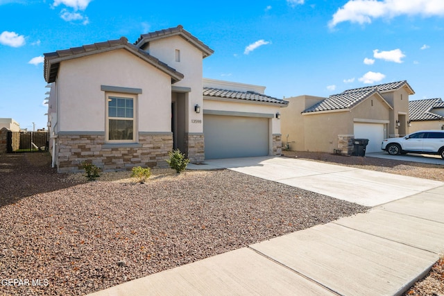 mediterranean / spanish-style home featuring stone siding, a garage, driveway, and stucco siding