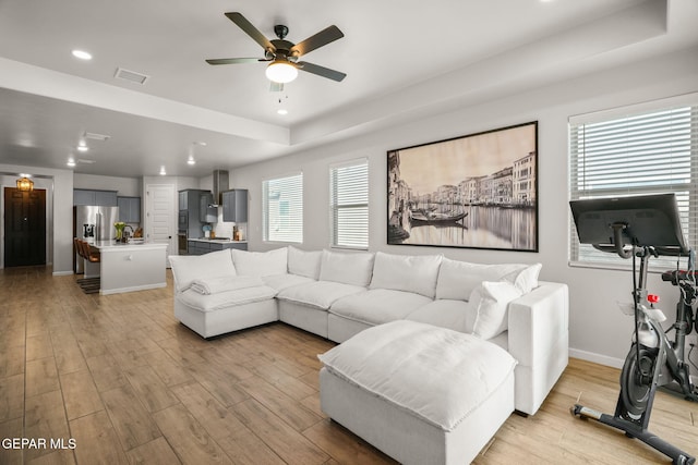 living room with recessed lighting, visible vents, baseboards, and light wood-style floors